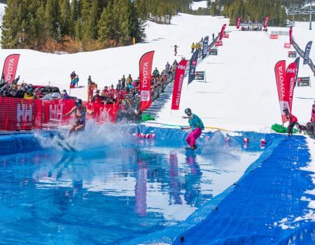 Breckenridge pond skim A skiier and a snowboarder float over water during the Breckenridge pond skim